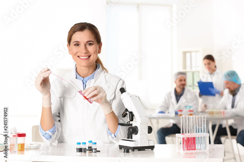 Portrait of female scientist working at table in laboratory, space for text. Research and analysis
