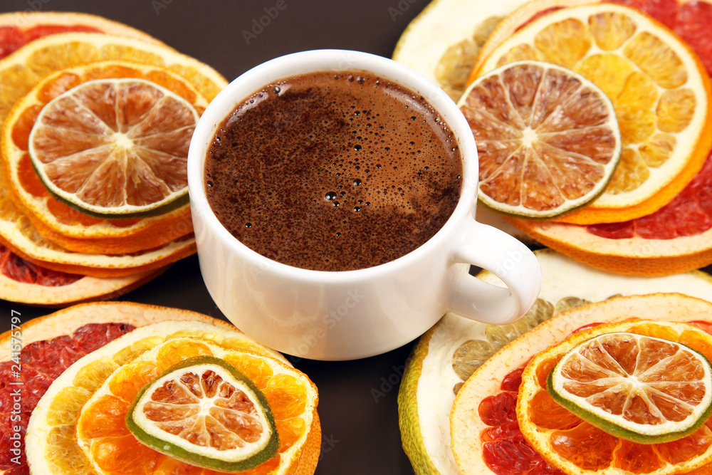 Dried slices of various citrus fruits and black coffee in a white Cup Dried slices of various citrus fruits and black coffee in a white Cup