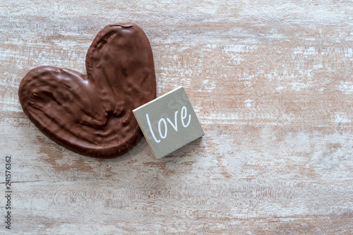 Cozy wooden background, with a chocolate palm tree, a piece of wood with the word love written, love concept, for Valentine's Day, Mother's Day, Father's Day, Christmas, holidays.