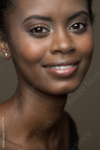 Close up beauty picture of a beautiful, young, black woman with a soft smile.