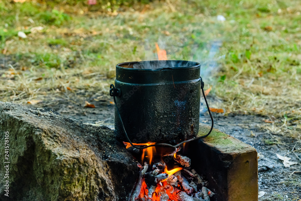 Cooking food in a kettle on bonfire Cooking food in a kettle on bonfire