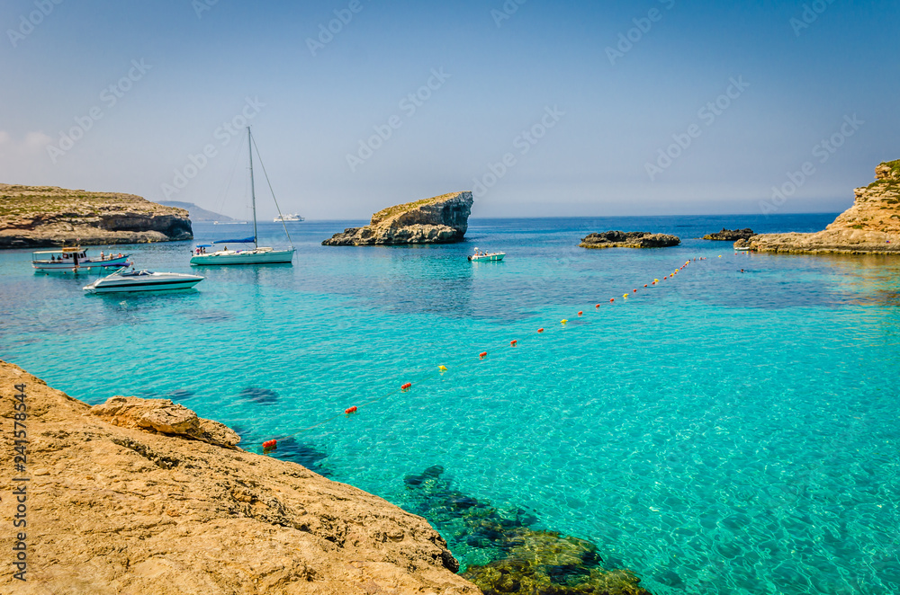 Fototapeta premium Blue Lagoon, Malta - the caves of the Blue Lagoon on the island of Comino on a bright sunny summer day with blue sky