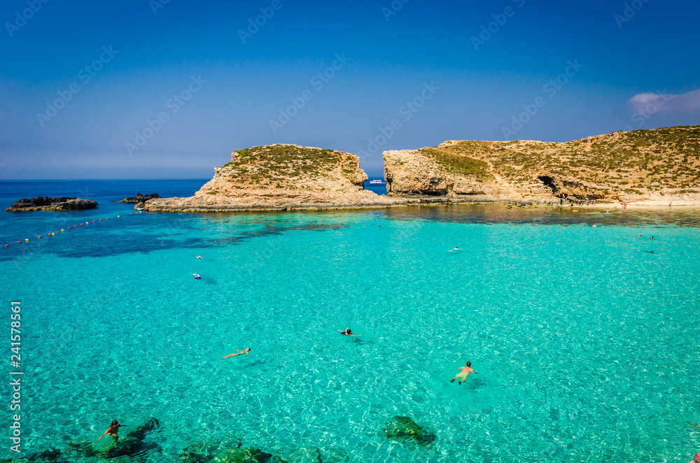 Blue Lagoon, Malta - the caves of the Blue Lagoon on the island of Comino on a bright sunny summer day with blue sky