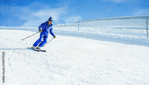 Young athlete skiing in alps mountains on weekend day - Skier riding down in winter snow resort for holidays time - Sport competition, travel, training and vacation concept - Focus on his head