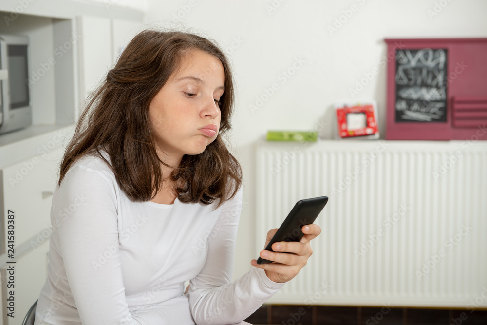 teenage girl using smartphone in the kitchen teenage girl using smartphone in the kitchen