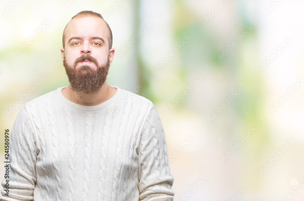 Young caucasian hipster man wearing winter sweater over isolated background puffing cheeks with funny face. Mouth inflated with air, crazy expression. Young caucasian hipster man wearing winter sweater over isolated background puffing cheeks with funny face. Mouth inflated with air, crazy expression.