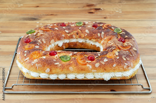 King's cake made by hand in the oven, placed on the oven rack, on a rustic wooden base.