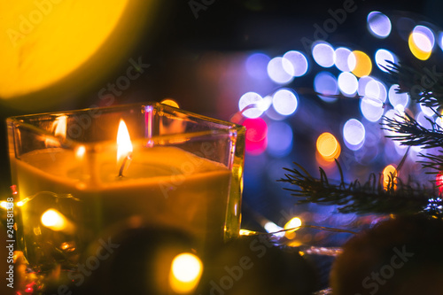 Christmas New Year Composition with candle, garlands, colorful lights, selective focus Black Background Holiday Decoration, copy space