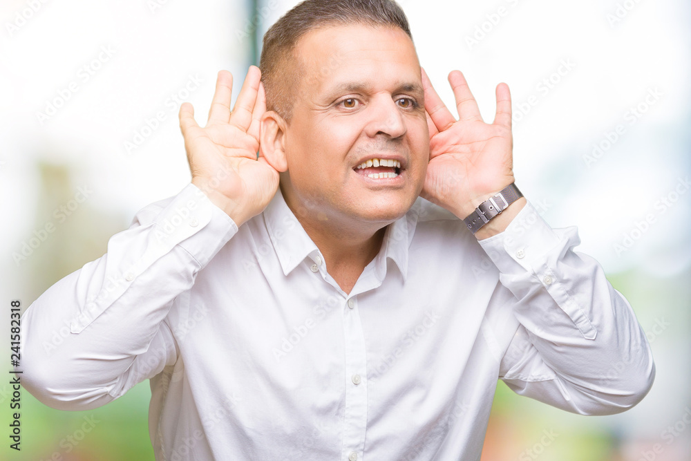 Middle age arab elegant man over isolated background Trying to hear both hands on ear gesture, curious for gossip. Hearing problem, deaf Middle age arab elegant man over isolated background Trying to hear both hands on ear gesture, curious for gossip. Hearing problem, deaf