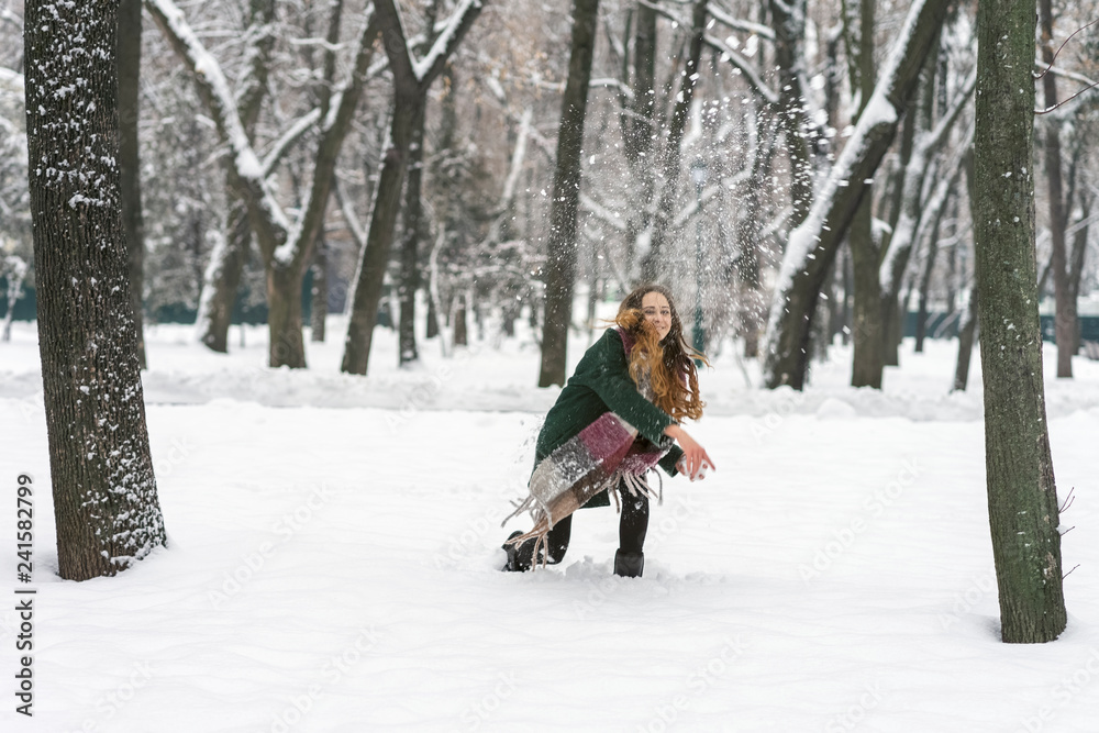 woman in the park throwing snowballs woman in the park throwing snowballs