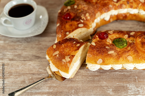 King's cake made by hand in the oven, on a cozy wooden base, with a cup of coffee.