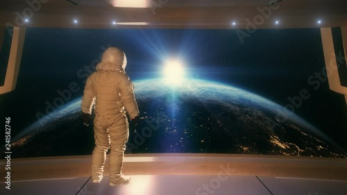 Astronaut seeing a sunrise over planet earth from a space station