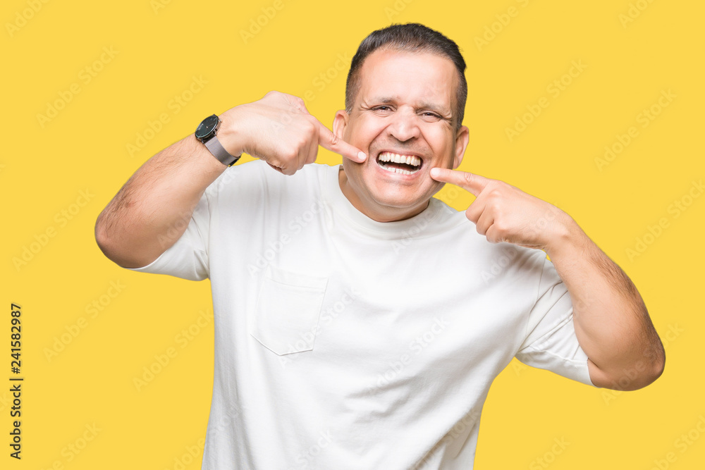 Middle age arab man wearig white t-shirt over isolated background smiling confident showing and pointing with fingers teeth and mouth. Health concept. Middle age arab man wearig white t-shirt over isolated background smiling confident showing and pointing with fingers teeth and mouth. Health concept.