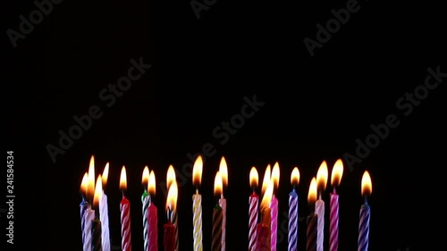 birthday candles light on isolated black