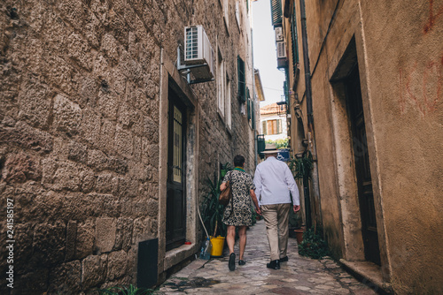 old couple walking by tight street of Kotor, Montenegro © phpetrunina14