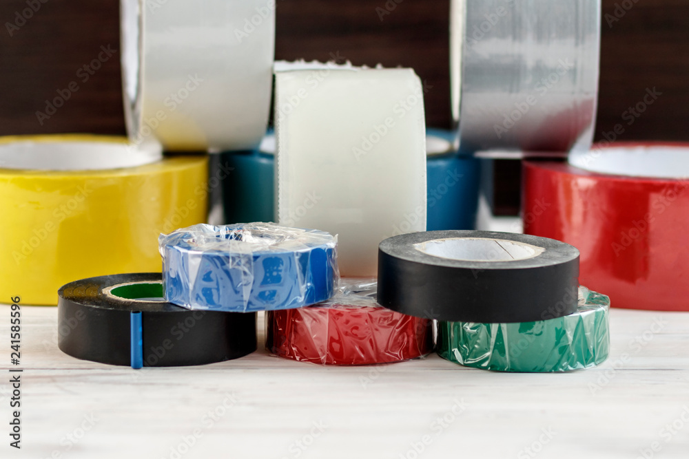 A few rolls of duct tape stack of electrical tape stand nearby. have