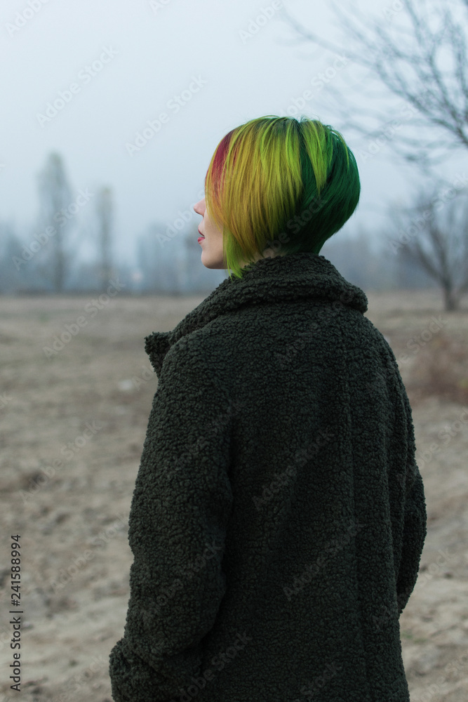 Woman in the desert in the fall in a coat with multi-colored hair. Woman in the desert in the fall in a coat with multi-colored hair.
