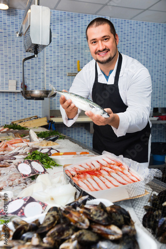Canvas Print Seller behind scales and fish counter showing fish