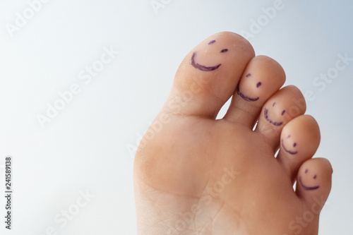 Female toes with painted smileys. photo