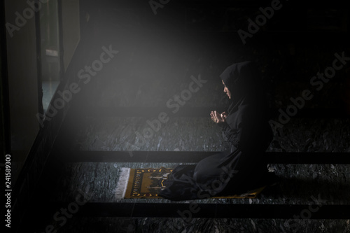 Muslim women wearing black shirts Doing prayer According to the principles of Islam..