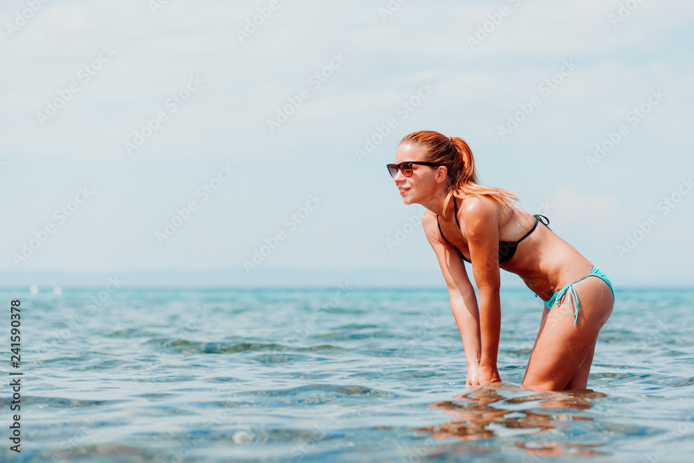 Young woman playing with water in the sea