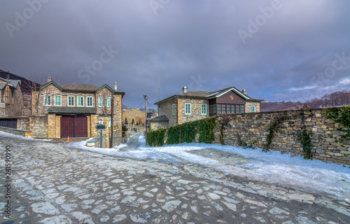 View of traditional stone buildings and streets with snow at the famous village of Nymfaio near Florina, Greece. 