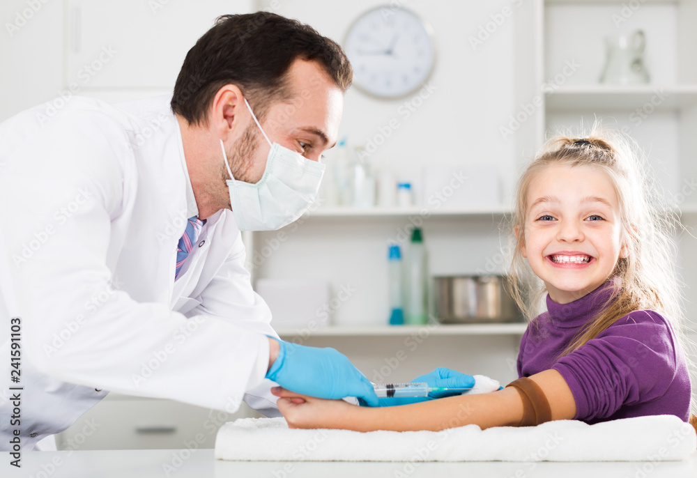 Fototapeta premium Smiling male ready to make injection to visitor