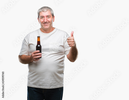 Handsome senior man drinking beer bottle over isolated background happy with big smile doing ok sign, thumb up with fingers, excellent sign