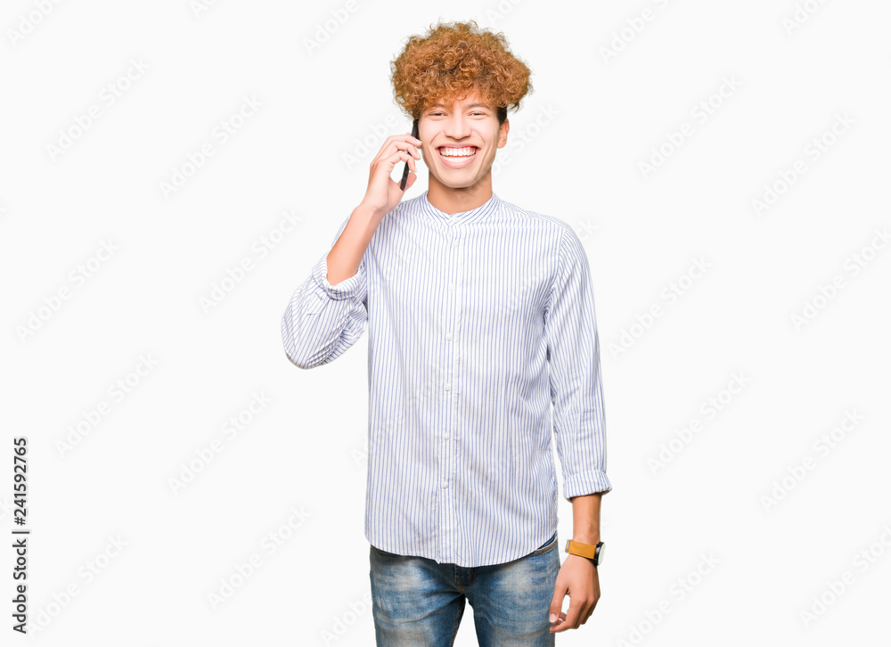 Young handsome man talking on the phone with a happy face standing and smiling with a confident smile showing teeth Young handsome man talking on the phone with a happy face standing and smiling with a confident smile showing teeth