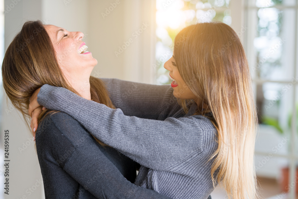 Beautiful family of mother and daughter together, hugging and kissing at home Beautiful family of mother and daughter together, hugging and kissing at home