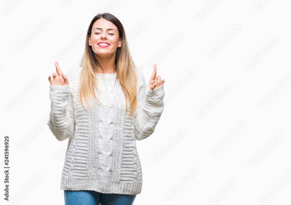Young beautiful woman casual white sweater over isolated background smiling crossing fingers with hope and eyes closed. Luck and superstitious concept. Young beautiful woman casual white sweater over isolated background smiling crossing fingers with hope and eyes closed. Luck and superstitious concept.