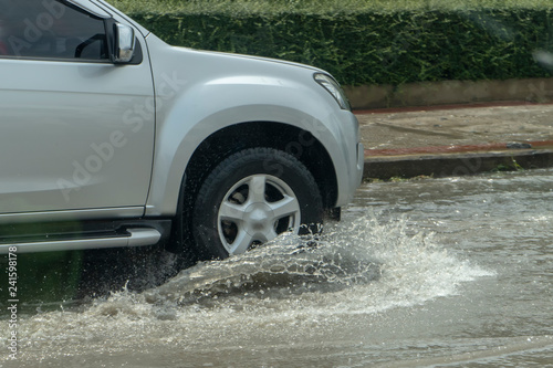 Truck driving through flood water on the road