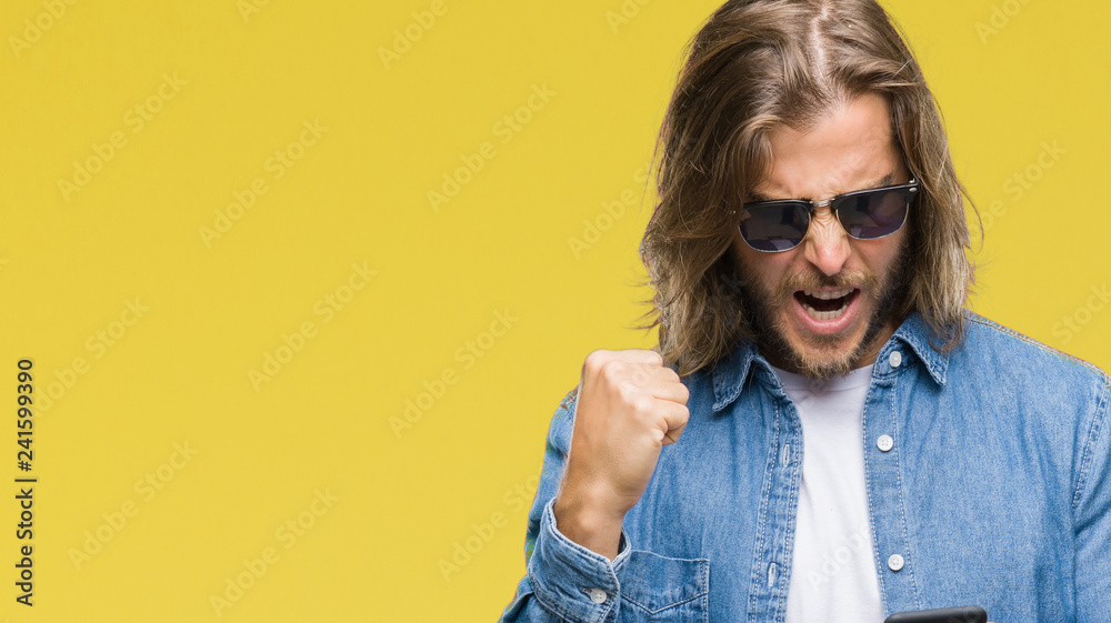 Fototapeta premium Young handsome man with long hair over isolated background sending message using smartphone annoyed and frustrated shouting with anger, crazy and yelling with raised hand, anger concept