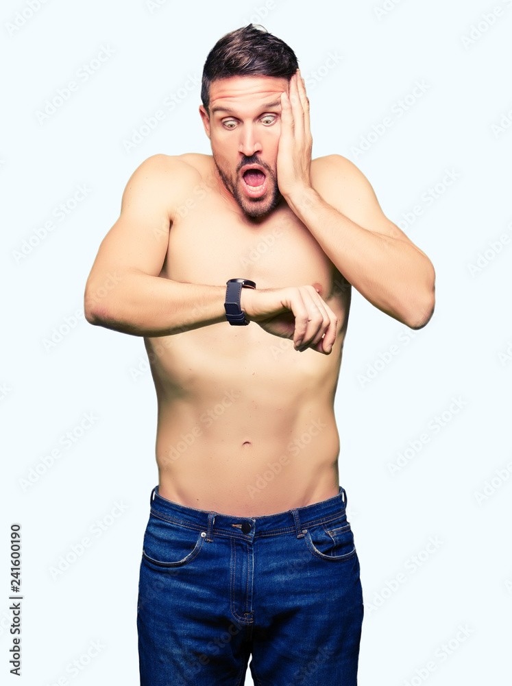 Handsome shirtless man showing nude chest Looking at the watch time worried, afraid of getting late