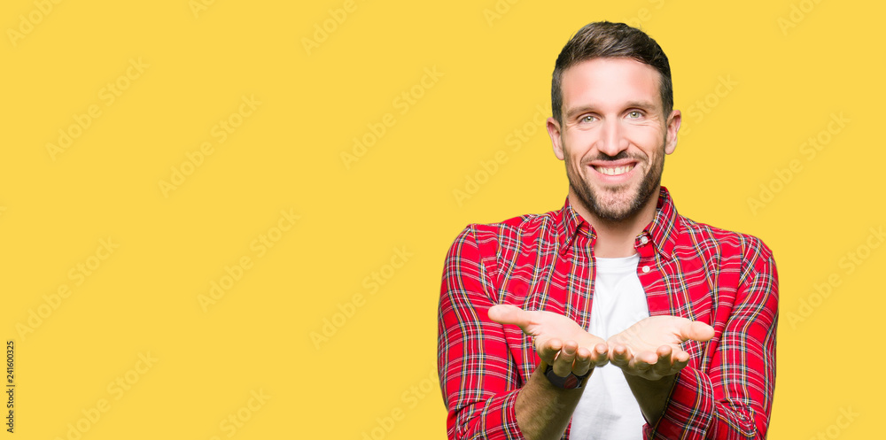 Handsome man wearing casual shirt Smiling with hands palms together receiving or giving gesture. Hold and protection Handsome man wearing casual shirt Smiling with hands palms together receiving or giving gesture. Hold and protection