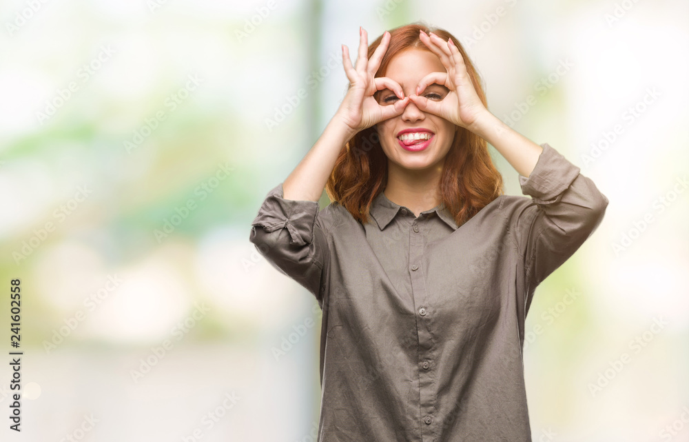 Young beautiful woman over isolated background doing ok gesture like binoculars sticking tongue out, eyes looking through fingers. Crazy expression. Young beautiful woman over isolated background doing ok gesture like binoculars sticking tongue out, eyes looking through fingers. Crazy expression.