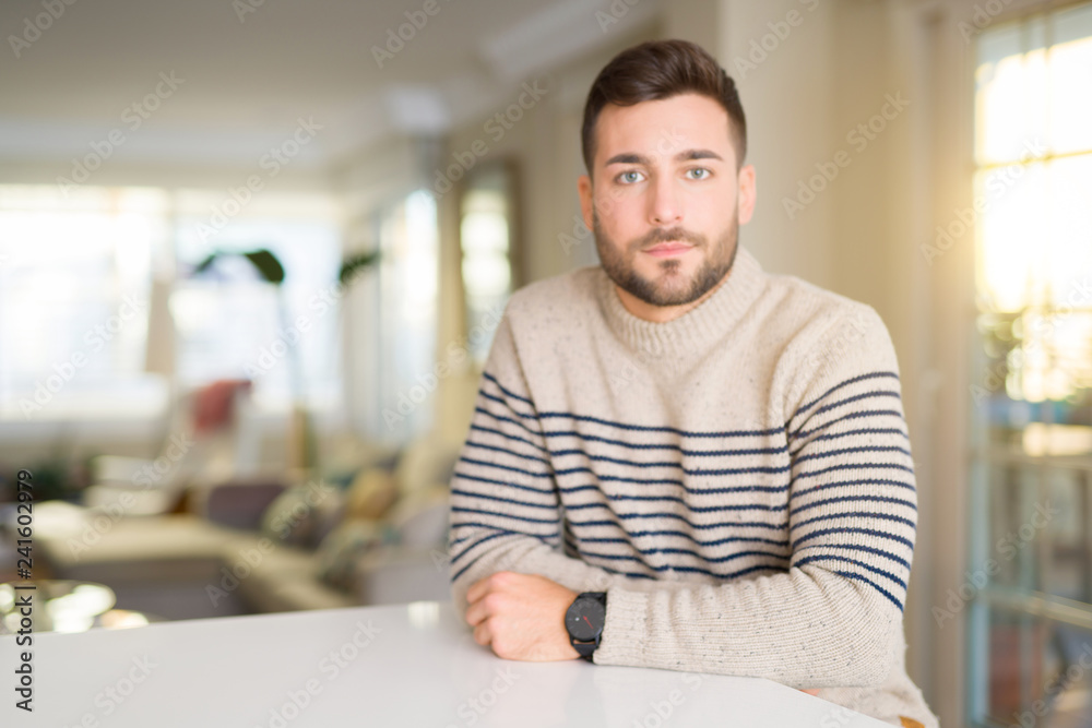 Young handsome man at home with serious expression on face. Simple and natural looking at the camera. Young handsome man at home with serious expression on face. Simple and natural looking at the camera.