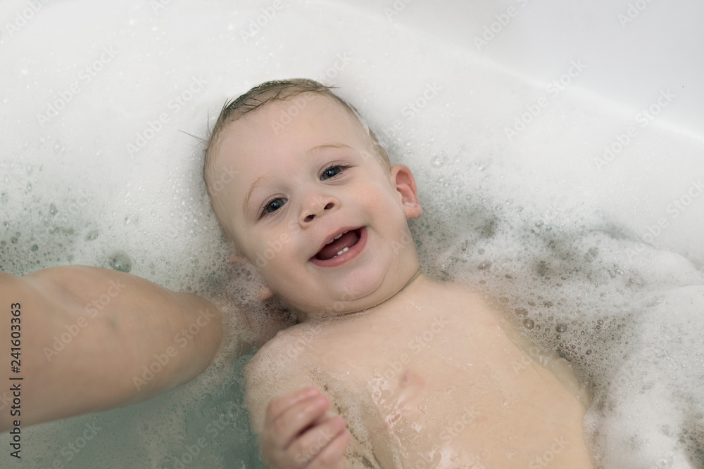 Kid, baby boy taking bath, having fun in foam Kid, baby boy taking bath, having fun in foam