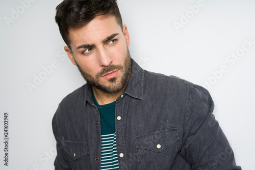 Young handsome man possing and modeling over grey isolated background