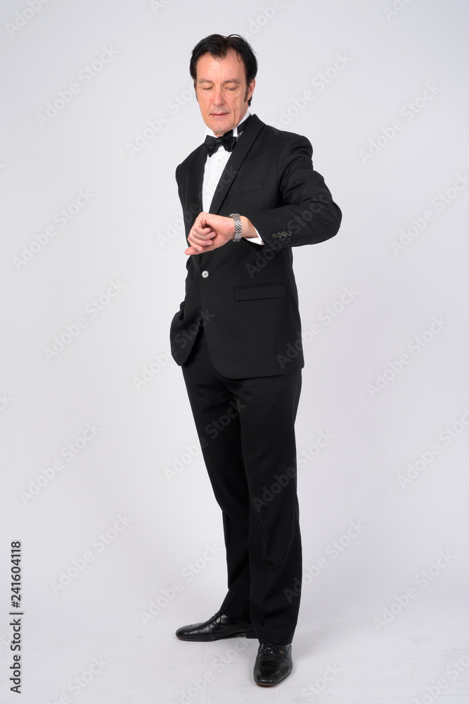 Full body shot of mature handsome businessman checking time Full body shot of mature handsome businessman checking time