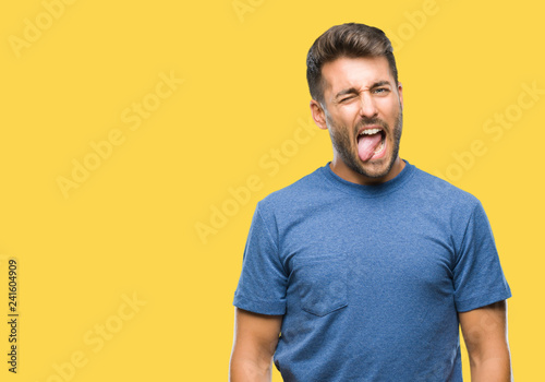 Young handsome man over isolated background sticking tongue out happy with funny expression. Emotion concept.