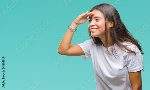 Young beautiful arab woman over isolated background very happy and smiling looking far away with hand over head. Searching concept.