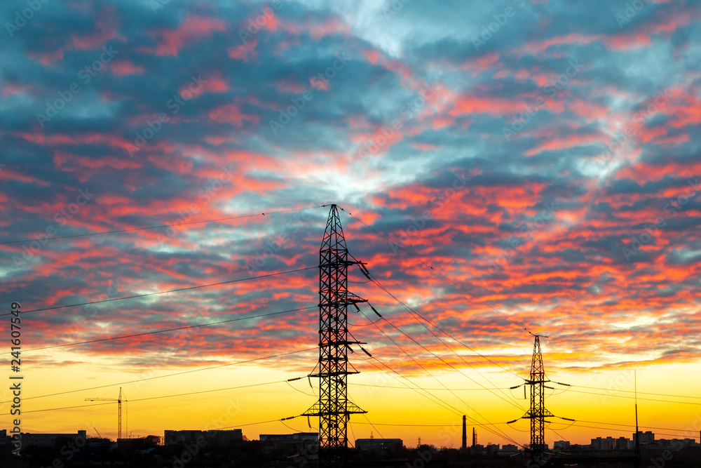 High-voltage electricity pylon and power line against the sunset sky