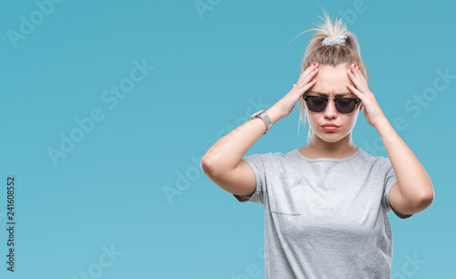Young blonde woman wearing sunglasses over isolated background suffering from headache desperate and stressed because pain and migraine. Hands on head. © Krakenimages.com
