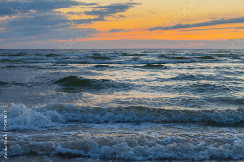 Low waves on Baltic sea at sunset. Cosy flat sandy beach. © yegorov_nick