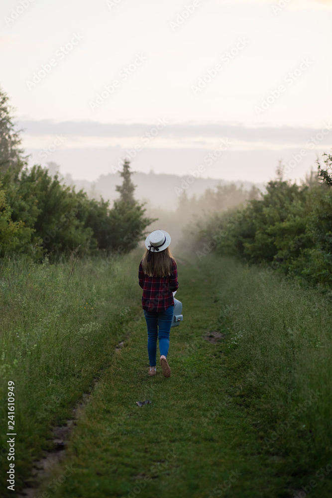 single girl meets sunrise in a misty morning in a field in summer