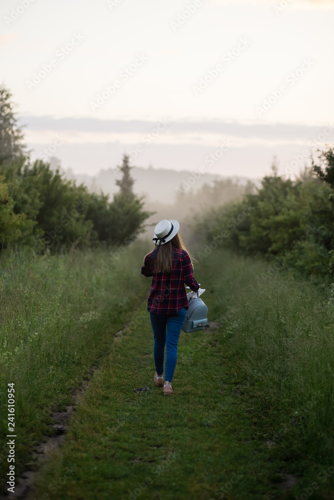 single girl meets sunrise in a misty morning in a field in summer