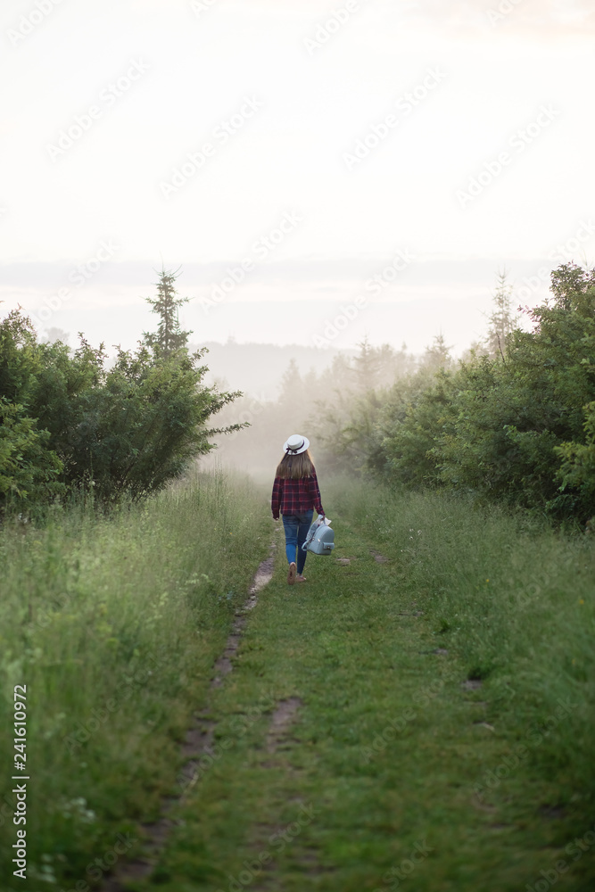 single girl meets sunrise in a misty morning in a field in summer