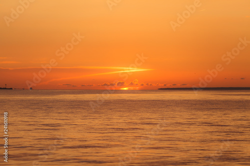 Colourful orange sunset with bright clear sky over Baltic sea.