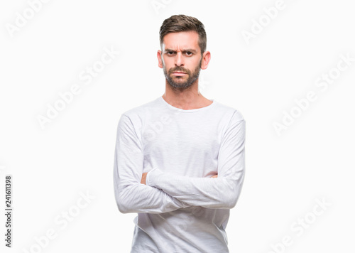 Young handsome man over isolated background skeptic and nervous, disapproving expression on face with crossed arms. Negative person. © Krakenimages.com